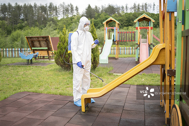 用喷雾化学品清洁和消毒游乐场滑梯图片素材