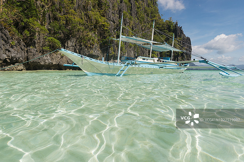 邦卡岛螃蟹船：在巴奎群岛埃尔尼多浮潜之旅中停泊的白色透明船只，巴拉望岛图片素材