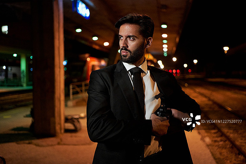 神情疑惑的侦探从枪套里拔出手枪图片素材