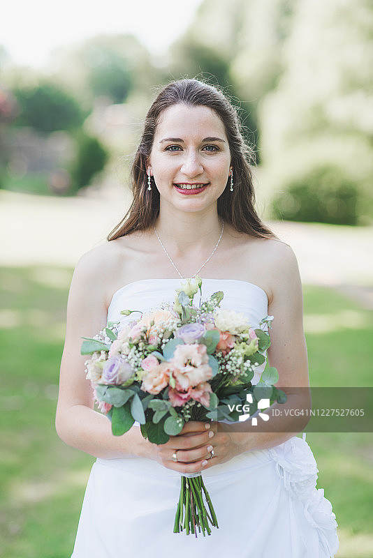 手捧结婚花束的微笑新娘肖像图片素材