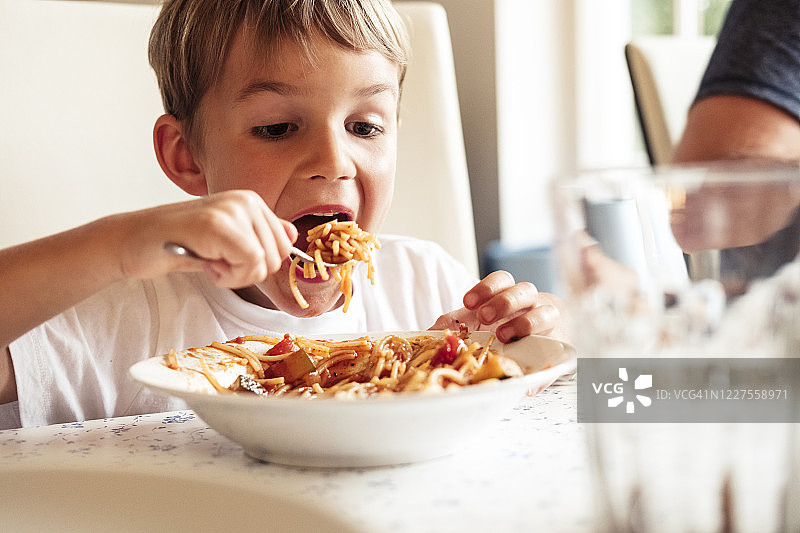 吃意大利面的男孩肖像图片素材