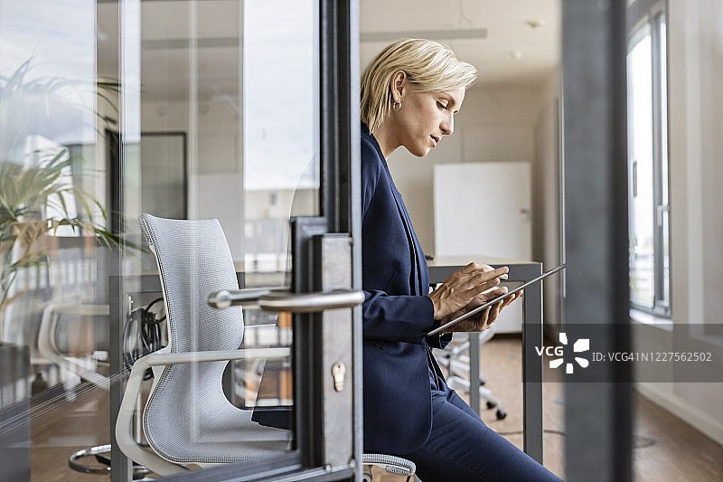 在会议室使用平板电脑的金发女商人图片素材