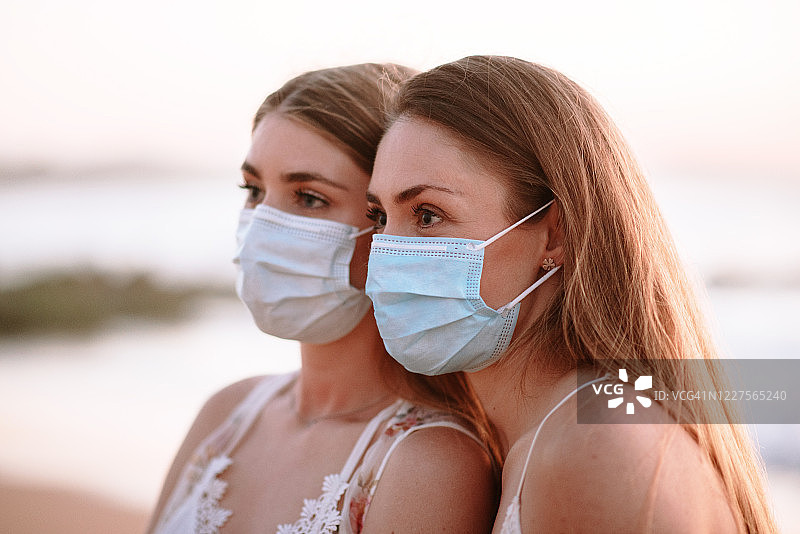 在海滩上戴防护口罩的两名年轻女子图片素材