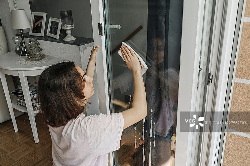 少女清洁阳台门的玻璃图片素材
