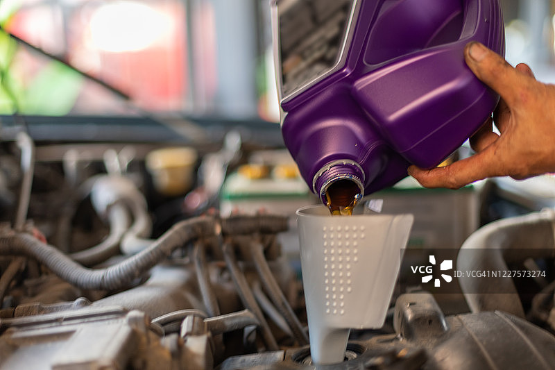 换油，机械师正在转移汽车发动机油图片素材