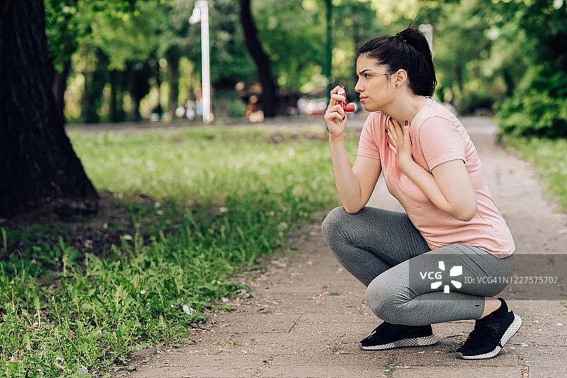 女孩在慢跑时使用哮喘吸入器图片素材