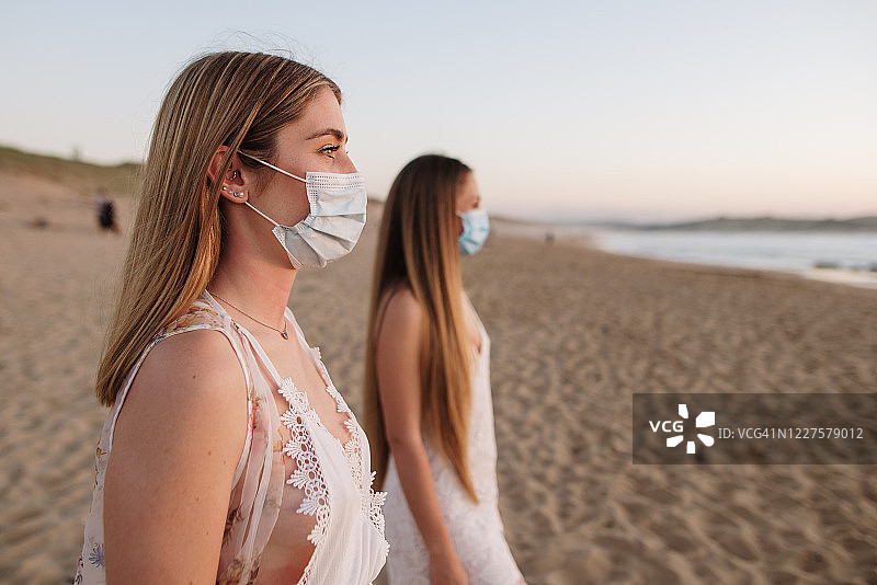 在海滩上戴防护口罩的两名年轻女子图片素材