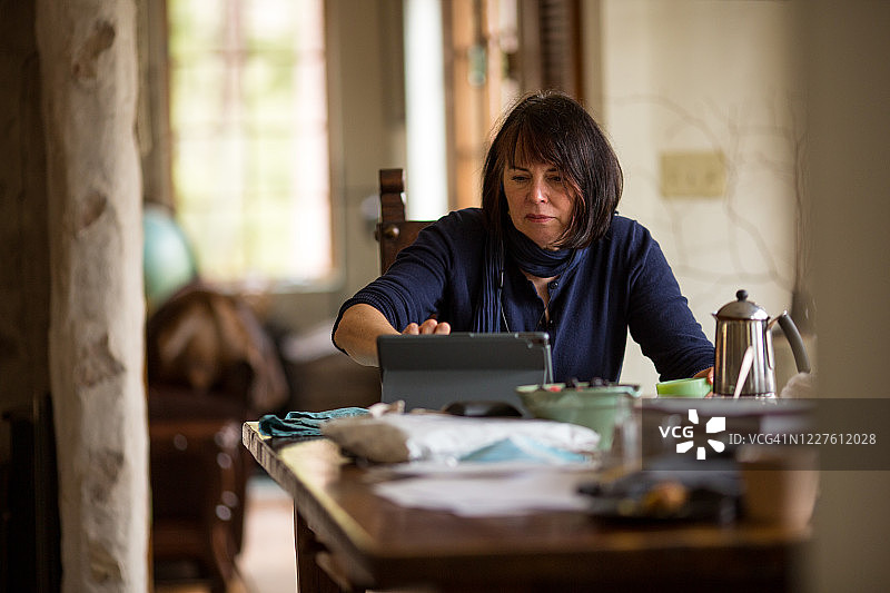 女人在厨房餐桌旁居家办公图片素材