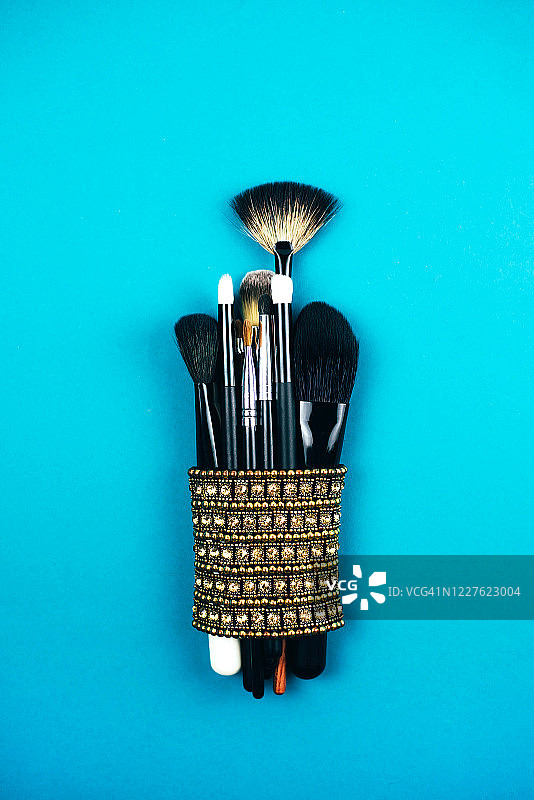 大量化妆刷，背景为蓝绿色图片素材