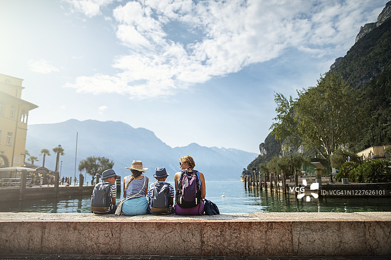 一家人坐在加尔达里瓦港口欣赏加尔达湖的景色图片素材