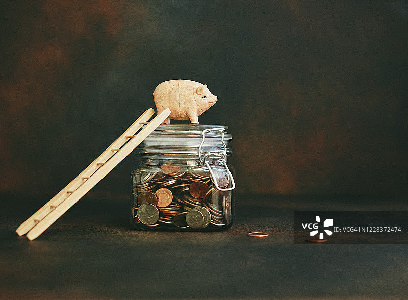 装满硬币和梯子的小猪存钱罐图片素材