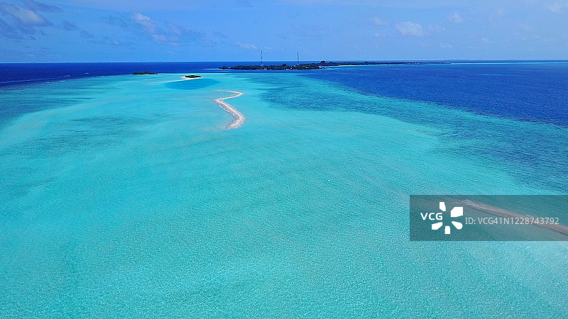 牙买加绿松石色海水中环绕的沙洲鸟瞰图，柔和的海浪拍打着沙洲图片素材