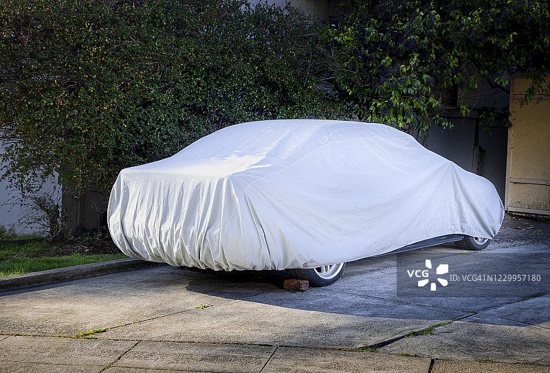 盖着布的汽车在车道上图片素材