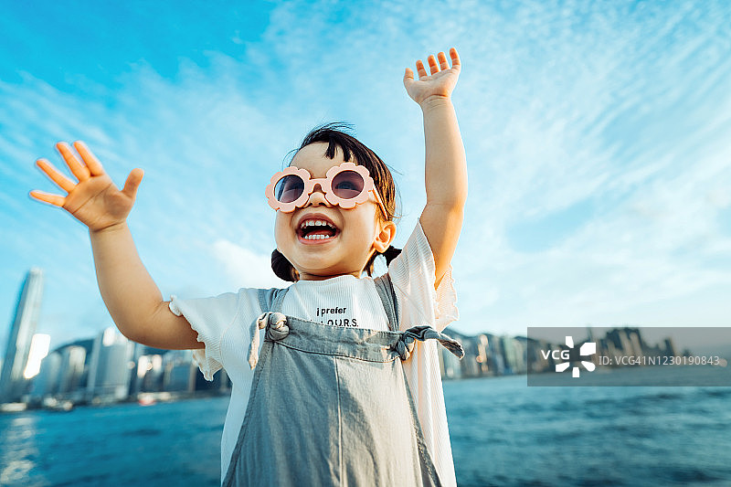 戴着花形太阳镜的快乐亚洲小女孩在户外玩耍图片素材