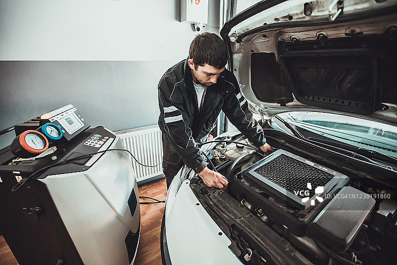 汽车修理工给汽车空调加氟图片素材