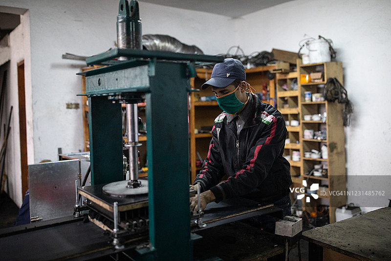 员工在工厂用液压机压制椰子炭图片素材