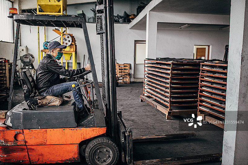 男人在工厂里骑着叉车搬运水烟用煤图片素材
