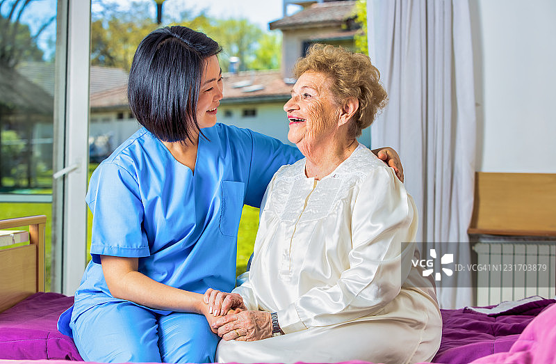 居家医疗保健：亚洲护士安慰刚醒来的老妇人图片素材