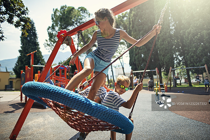 孩子们一起在一个大秋千上荡秋千图片素材