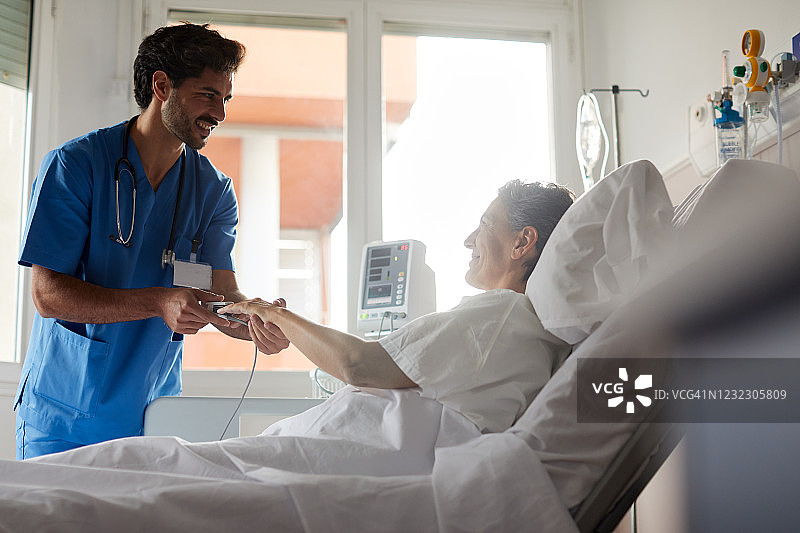 男护士用指式血氧仪测量脉搏图片素材