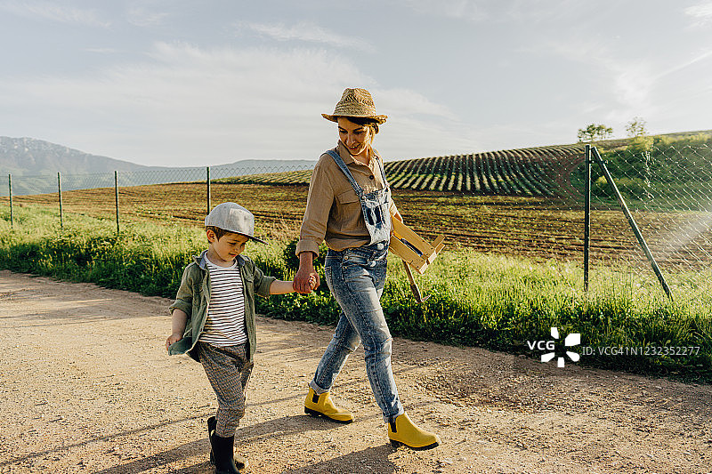 微笑的男孩和他的妈妈参观家庭农场图片素材