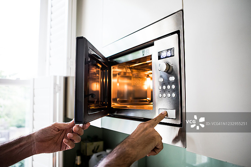 用微波炉加热/烹饪食物图片素材