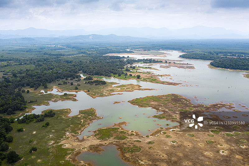 泰国宋卡府干涸的湖泊航拍，秋季绿湖干涸，湖岸线森林茂密，湖水呈黑色图片素材