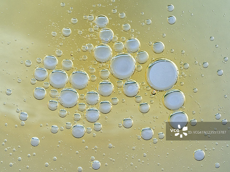 金色液体背景上的气泡和水滴纹理抽象形状图片素材