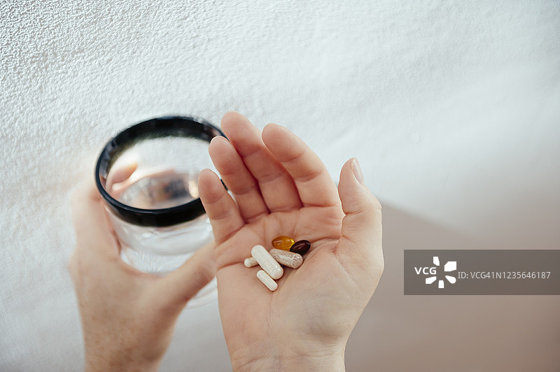 手持维生素和水的特写图片素材