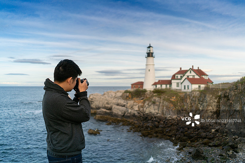亚洲男人在缅因州拍摄波特兰灯塔图片素材
