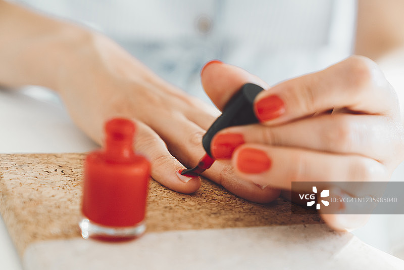 正在涂红色指甲油的女士图片素材