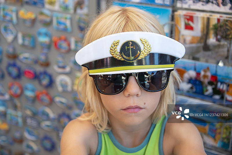 戴着水手帽服饰配件的严肃年轻男孩，莱夫卡达，希腊图片素材