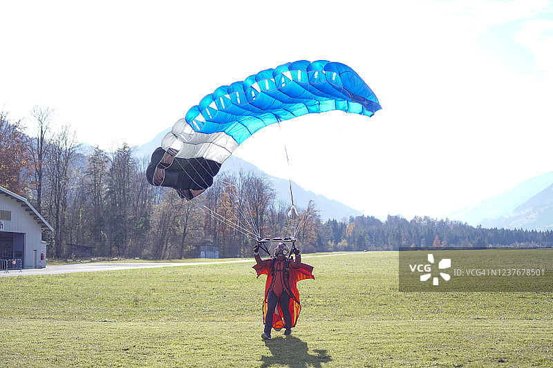 翼装飞行员/滑翔伞运动员准备着陆，降落伞已打开图片素材