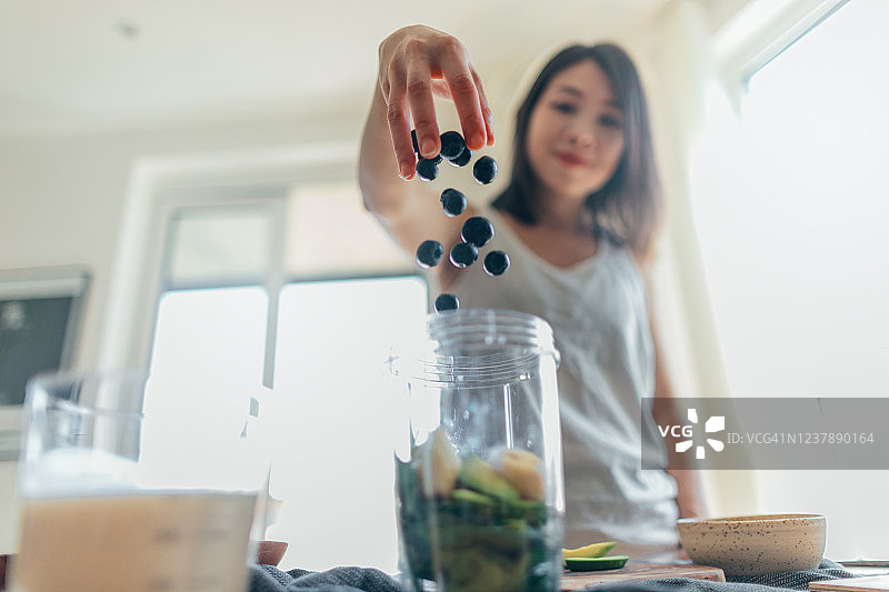 年轻女人为早餐制作健康冰沙图片素材