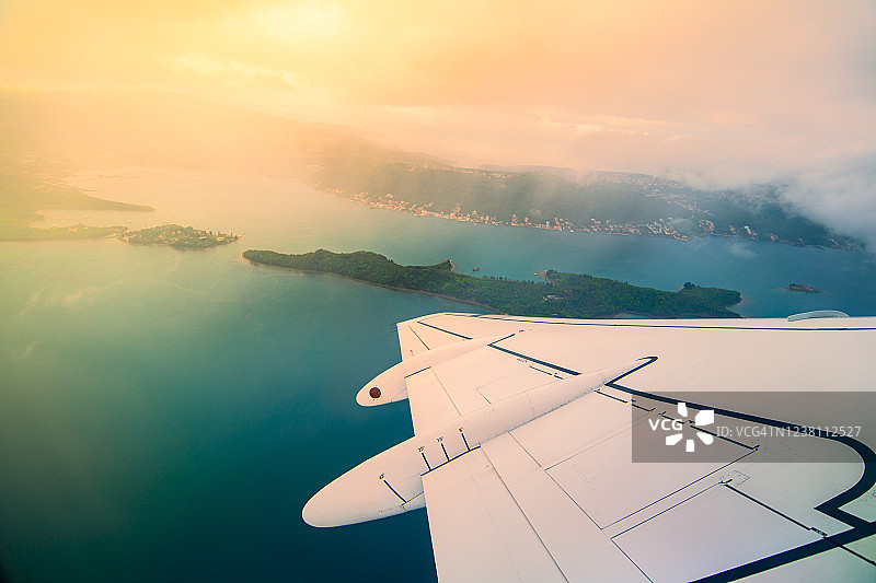 飞机旅行度假概念：舷窗外的海湾和岛屿景观图片素材