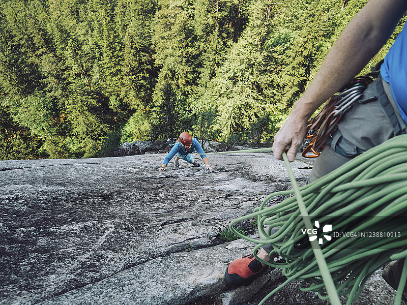 攀岩者的攀岩同伴在上方保护图片素材