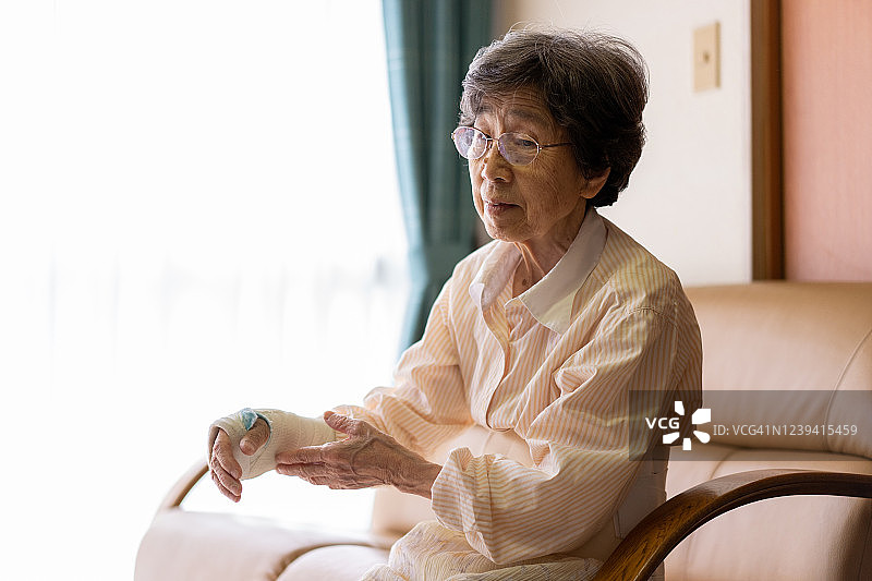 手腕骨折的老年妇女在家接受治疗图片素材