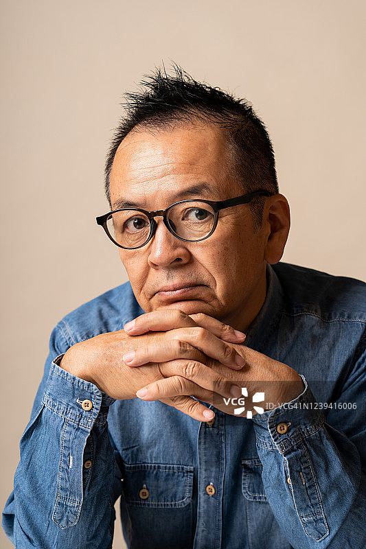 留着柔软莫霍克发型的日本老年男人影棚肖像图片素材