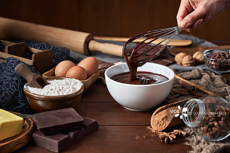 在乡村厨房的木桌上，女人手制巧克力慕斯和饼干图片素材