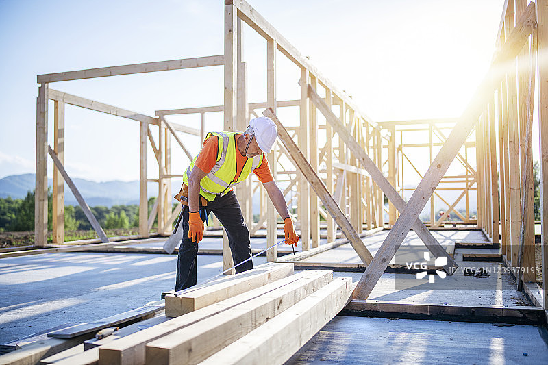 建筑工人在木制建筑结构上工作图片素材