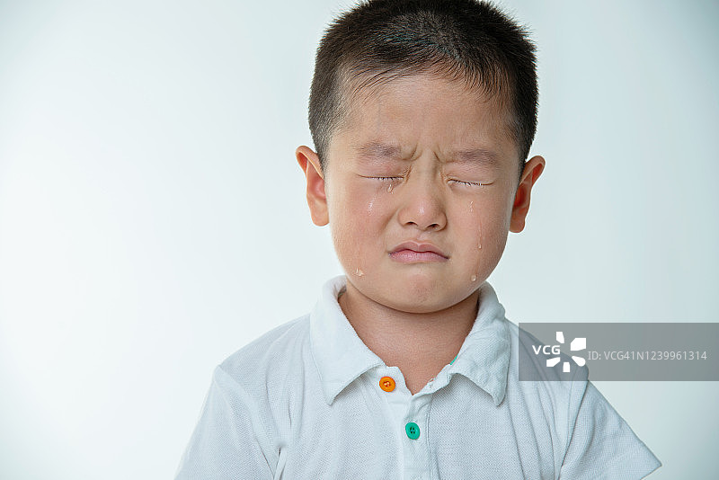在白色背景下哭泣的亚洲男孩图片素材