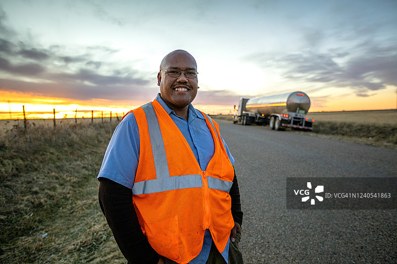 司机在乡村公路的运奶车旁摆姿势图片素材
