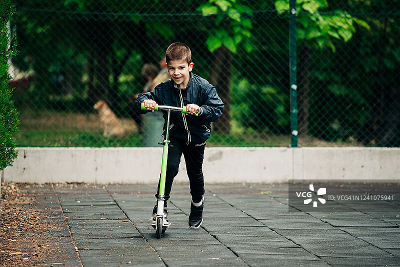 小男孩骑滑板车图片素材