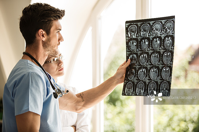 肿瘤科医生查看脑肿瘤X光扫描图片素材