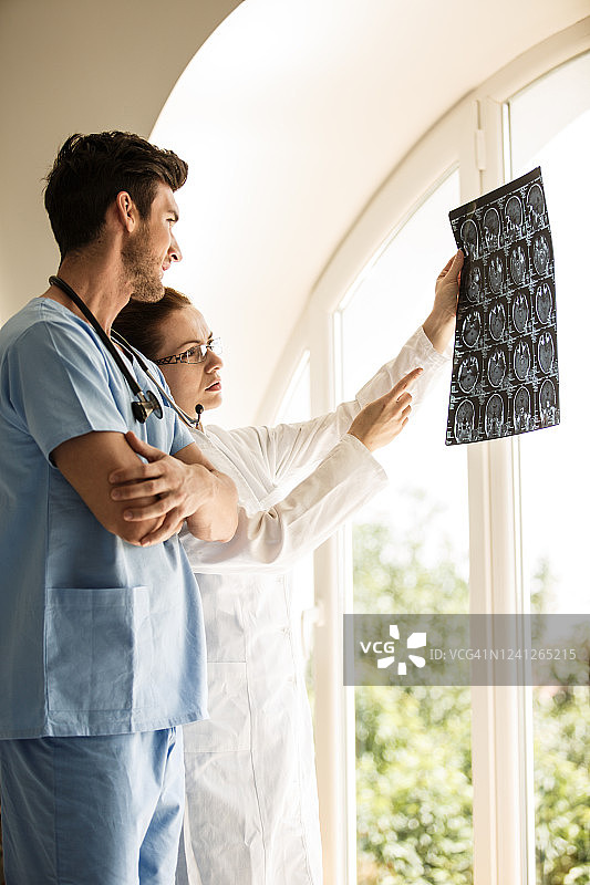 两位肿瘤科医生讨论脑肿瘤的MRI扫描结果图片素材