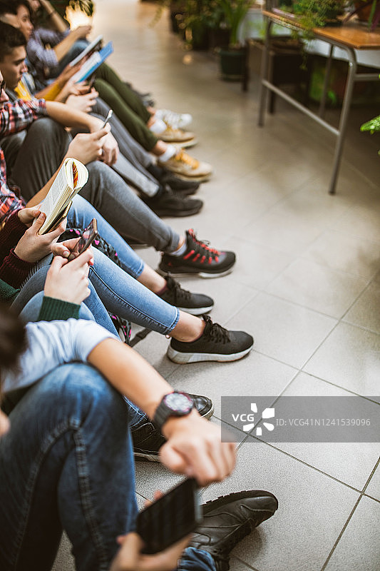 一群学生在走廊的地板上放松图片素材