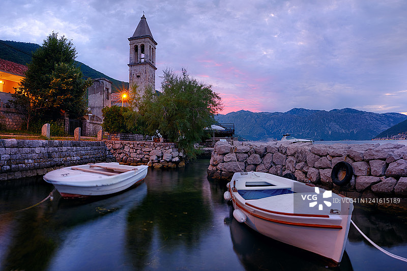 海边小镇：前景是船只，背景是古老的石塔图片素材