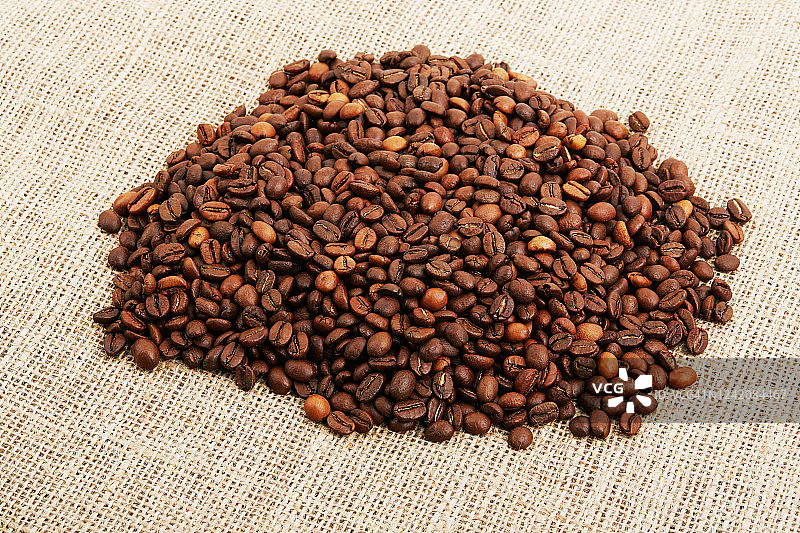粗麻布背景上的烘焙咖啡豆图片素材