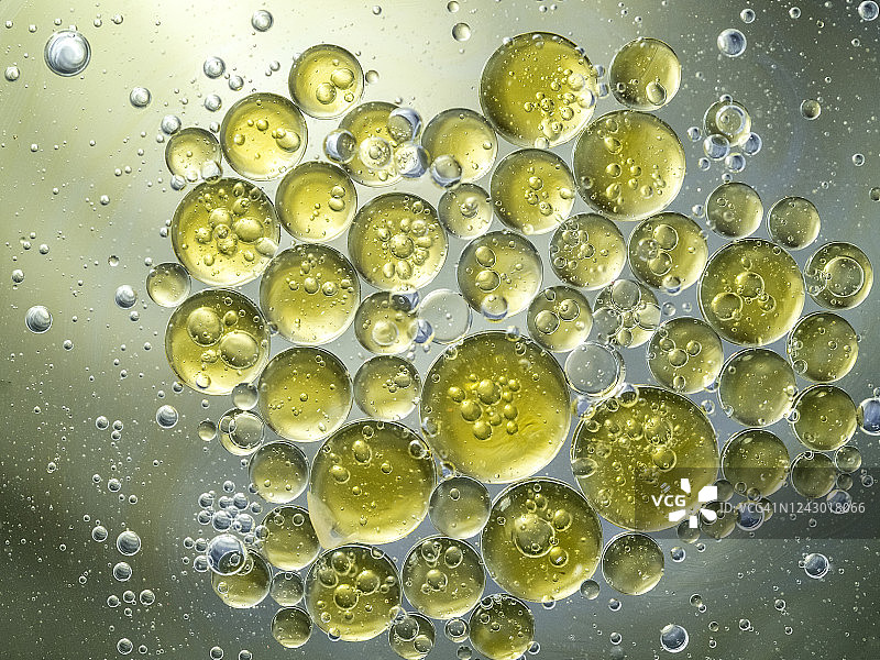 金色液体背景上的气泡和水滴纹理抽象形状图片素材