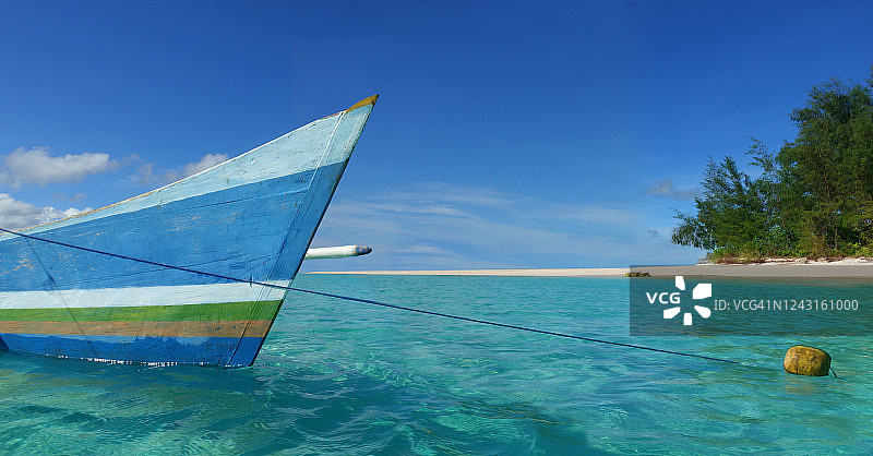 停泊在热带岛屿附近的船图片素材